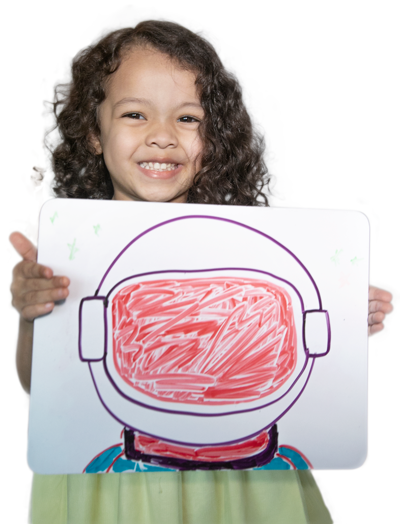 A smiling girl holds up her drawing of an astronaut helmet