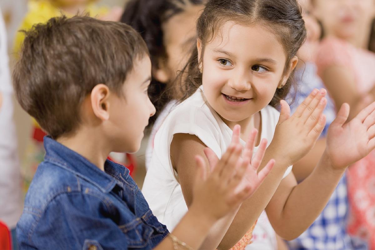 Preschoolers clap along together during circle time